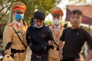 Lực lượng chức năng bàn giao 2 thanh niên (áo đen) và tang vật cho cơ quan Công an.