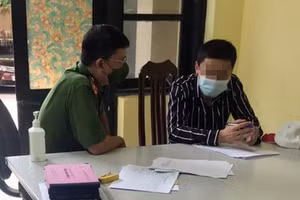 Đối tượng N.N (bên phải) tại cơ quan công an. 