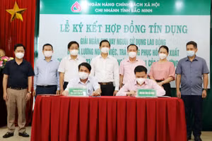 Phó Chủ tịch Thường trực UBND tỉnh Vương Quốc Tuấn (thứ 4 hàng sau) chứng kiến ký kết giữa Ngân hàng Chính sách xã hội tỉnh và các doanh nghiệp. 