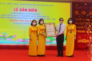 Bí thư Quận ủy Hoàng Minh Dũng Tiến trao bằng công nhận công trình cấp thành phố cho trường TH Kim Đồng. 