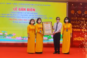 Bí thư Quận ủy Hoàng Minh Dũng Tiến trao bằng công nhận công trình cấp thành phố cho trường TH Kim Đồng. 