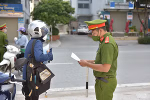 Lực lượng chức năng tuyên truyền nhắc nhở người dân thực hiện quy định phòng chống dịch.