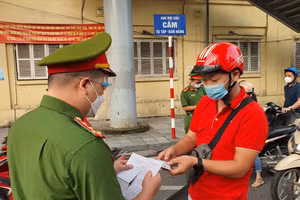 Lực lượng chức năng kiểm tra giấy đi đường tại chốt phòng dịch.