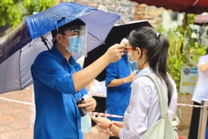 Đo thân nhiệt tại điểm thi Trường THCS Ba Đình (quận Ba Đình).