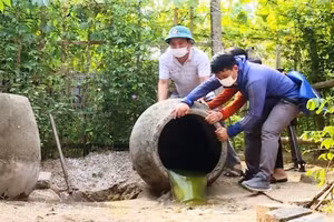 Lực lượng Y tế và người dân ở phường Hải Thanh (thị xã Nghi Sơn, Thanh Hóa) đổ kiệt nước đọng trong các chum để phòng dịch sốt xuất huyết.