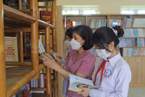 Cô Lê Thị Nhung cùng học sinh Trường THCS Nhữ Bá Sỹ (Hoằng Hóa, Thanh Hóa) đọc sách tại thư viện.