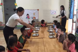 Giáo viên Trường Mầm non Tam Chung, huyện Mường Lát (Thanh Hóa) lo bữa ăn bán trú cho trẻ.