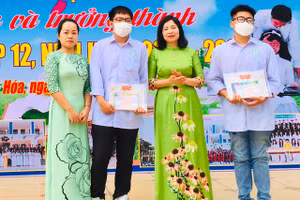 Cô Nguyễn Thị Lệ (ảnh giữa) - Hiệu trưởng Trường THPT Tô Hiến Thành (TP Thanh Hóa) trao thương cho hai học sinh Khánh và Mạnh.