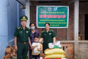 Đại tá Lê Văn Anh và Đại úyLê Thanh Nhanh, Chủ tịch Hội phụ nữ bộ đội Biên phòng Sóc Trăng trao quà cho em Lâm. 