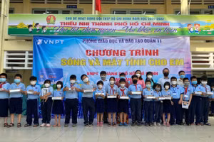 Học sinh trường Tiểu học Phú Thọ vui mừng nhận máy tính bảng từ các đơn vị trao tặng.