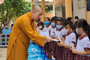 Đại đức Thích Nguyên Thông tặng quà cho các em học sinh nghèo.