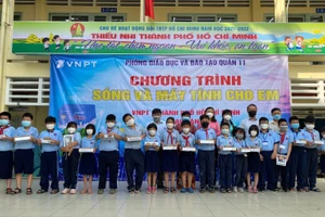 Học sinh trường Tiểu học Phú Thọ vui mừng nhận máy tính bảng từ các đơn vị trao tặng.