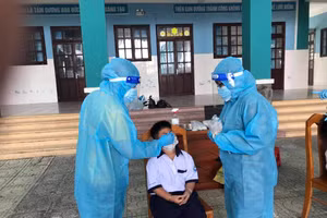 Nhân viên y tế xét nghiệm tầm soát Covid-19 đối với học sinh trường Tiểu học Thạnh An (huyện Cần Giờ, TPHCM)