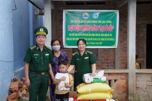 Đại tá Lê Văn Anh và Đại úyLê Thanh Nhanh, Chủ tịch Hội phụ nữ bộ đội Biên phòng Sóc Trăng trao quà cho em Lâm. 