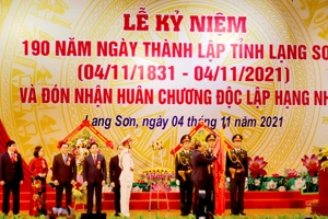 Chủ tịch nước Nguyễn Xuân Phúc gắn Huân chương Độc lập hạng Nhất lên Quốc kỳ, trao tặng phần thưởng cao quý của Đảng và Nhà nước cho Đảng bộ, chính quyền, nhân dân các dân tộc tỉnh Lạng Sơn.