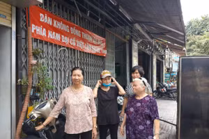 Người dân căng băng rôn với dòng chữ “dân không đồng thuận lấy nhà phía Nam đường Đại Cồ Việt lãm bãi xe tĩnh”.