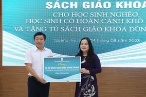 TS Lê Thị Hương, Giám đốc Sở GD&ĐT Quảng Trị tiếp nhận tượng trưng sách giáo khoa do ông Thừa Phú - Giám đốc NXBGD Việt Nam tại Đà Nẵng trao tặng.