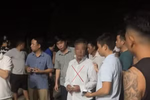 Người đàn ông nghi có hành vi bắt cóc trẻ em bị người dân giữ lại ở thôn Nam Hiếu, xã Cam Hiếu (huyện Cam Lộ) - Ảnh: MXH.