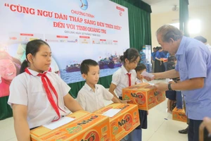 Ông Trương Hòa Bình, nguyên Phó Thủ tướng Thường trực Chính phủ trao học bổng đến học sinh.