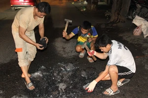 Những thành viên của đội vá đường tình nguyện miệt mài làm việc lúc tối trời.