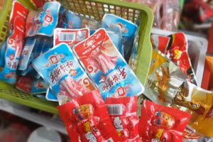 Chân gà ướp cay, xúc xích ăn liền, kẹo có vỏ đựng là chữ Trung Quốc, không tem phụ tiếng Việt. Ảnh: Huyền Trang.