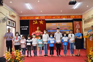 Đại diện LĐLĐ tỉnh Điện Biên và đơn vị tài trợ trao học bổng cho học sinh.
