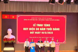 Bà Nguyễn Thị Là, Phó Bí thư Thường trực Đảng ủy Khối Đại học, Cao đẳng TPHCM (bìa phải) trao tặng Huy hiệu 30 năm tuổi Đảng cho các đảng viên. 