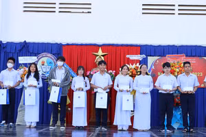 PGS.TS Vũ Văn Nhiêm (trái)- Chủ tịch Hội đồng Trường ĐH Luật TPHCM trao học bổng cho học sinh đặc biệt xuất sắc. 