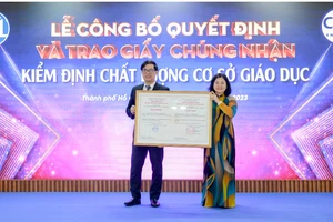 PGS. TS Phạm Tiến Đạt, Hiệu trưởng UFM (trái) đón nhận Giấy chứng nhận đạt chuẩn kiểm định từ Trung tâm Kiểm định chất lượng giáo dục - Đại học Quốc gia TPHCM. 