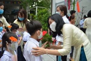 Hiệu trưởng Trường Tiểu học Lê Lai căn dặn và động viên HS lớp Một trong ngày đầu đến trường. 