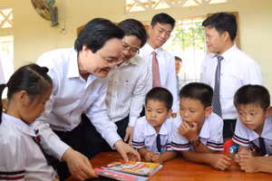 Bộ trưởng Phùng Xuân Nhạ chia sẻ, động viên thầy và trò xã Tân Hóa (Minh Hóa, Quảng Bình) vượt qua khó khăn sau trận lũ lớn xảy ra vào đầu năm học 2019 - 2020. Ảnh: TL