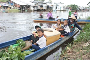 HS Trường Tiểu học A Khánh Bình Tây (huyện Trần Văn Thời, Cà Mau) đến trường bằng xuồng. 