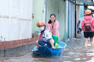 Phụ huynh ở TP Cần Thơ đưa HS đến trường bằng xuồng trong đợt triều cường sáng 20/10. Ảnh: Việt Hữu