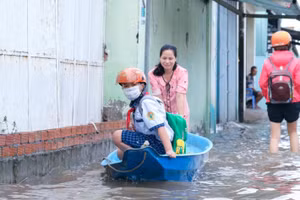 Phụ huynh ở TP Cần Thơ đưa HS đến trường bằng xuồng trong đợt triều cường sáng 20/10. Ảnh: Việt Hữu