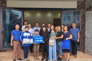 Thầy Đào Chí Mạnh ( thứ tư từ trái sang) trao hơn 30 triệu đồng và quà cho 2 chị em Trần Khánh An. Ảnh: NVCC