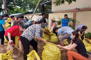 Thầy cô giáo Trường Tiểu học Thị trấn 1, huyện Vĩnh Thuận (Kiên Giang) gia cố trường học bằng bao cát để kịp đón HS trở lại lớp.