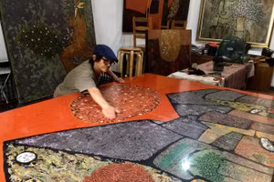 Họa sĩ Trịnh Tuân sáng tác tranh sơn mài tại gác riêng trên phố Lý Quốc Sư.