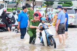 Nước ngập do triều cường khiến việc đến trường của HS Cần Thơ gặp nhiều khó khăn. 