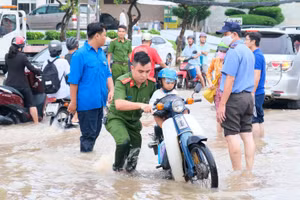 Nước ngập do triều cường khiến việc đến trường của HS Cần Thơ gặp nhiều khó khăn. 