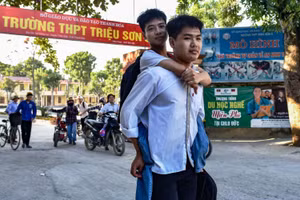 Ngô Văn Hiếu cõng Nguyễn Tất Minh tới trường.