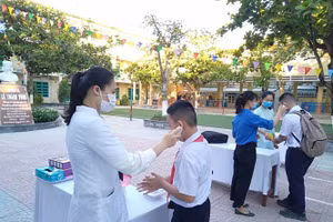 Học sinh được đo thân nhiệt và rửa tay bằng dung dịch sát khuẩn trước khi di chuyển về lớp học.