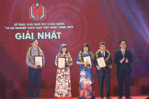Bộ Trưởng Bộ GD&ĐT Phùng Xuân Nhạ trao giải Nhất cho các tác giả và nhóm tác giả tại Giải báo chí vì sự nghiệp giáo dục Việt Nam năm 2019. Ảnh tư liệu: Thế Đại