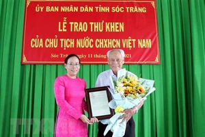 Phó Chủ tịch UBND tỉnh Sóc Trăng Huỳnh Thị Diễm Ngọc trao thư khen của Chủ tịch nước cho ông Trần Cang. Ảnh: TTXVN.
