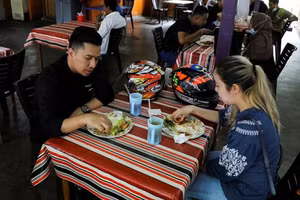 Người được tiêm chủng đầy đủ dùng bữa tại một nhà hàng, giữa lúc bùng phát COVID-19 ở Kuala Lumpur, Malaysia.