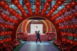 Một người đeo khẩu trang đi qua địa điểm được trang trí đèn lồng đón tết Tân Sửu 2021 tại Malaysia.