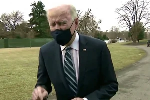 TT Joe Biden dường như đưa tay xuyên qua chiếc microphone.