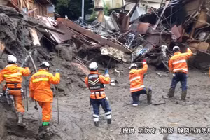 Nhân viên cứu hộ Nhật Bản tìm người mất tích sau vụ lở đất kinh hoàng.