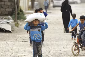 Một cậu bé mang thực phẩm do Chương trình Lương thực Thế giới của LHQ cung cấp ở Raqqa, Syria - về nhà.