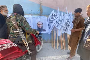 Thành viên Taliban đứng gần tấm áp phích của thủ lĩnh Mullah Haibatullah Akhundzada, ở Kabul, Afghanistan.
