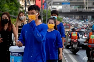 Nhân viên văn phòng và công nhân xây dựng đeo khẩu trang ở Thái Lan.